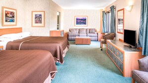 A hotel room with two beds, a sofa, a TV, and a desk. - Travelodge by Wyndham Kalispell (Kalispell)