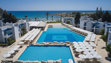 Una piscina techada, 2 piscinas al aire libre, sombrillas