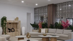 A modern living room with a sofa, two coffee tables, and decorative items. - Atlantica Callisto (Ayia Napa)