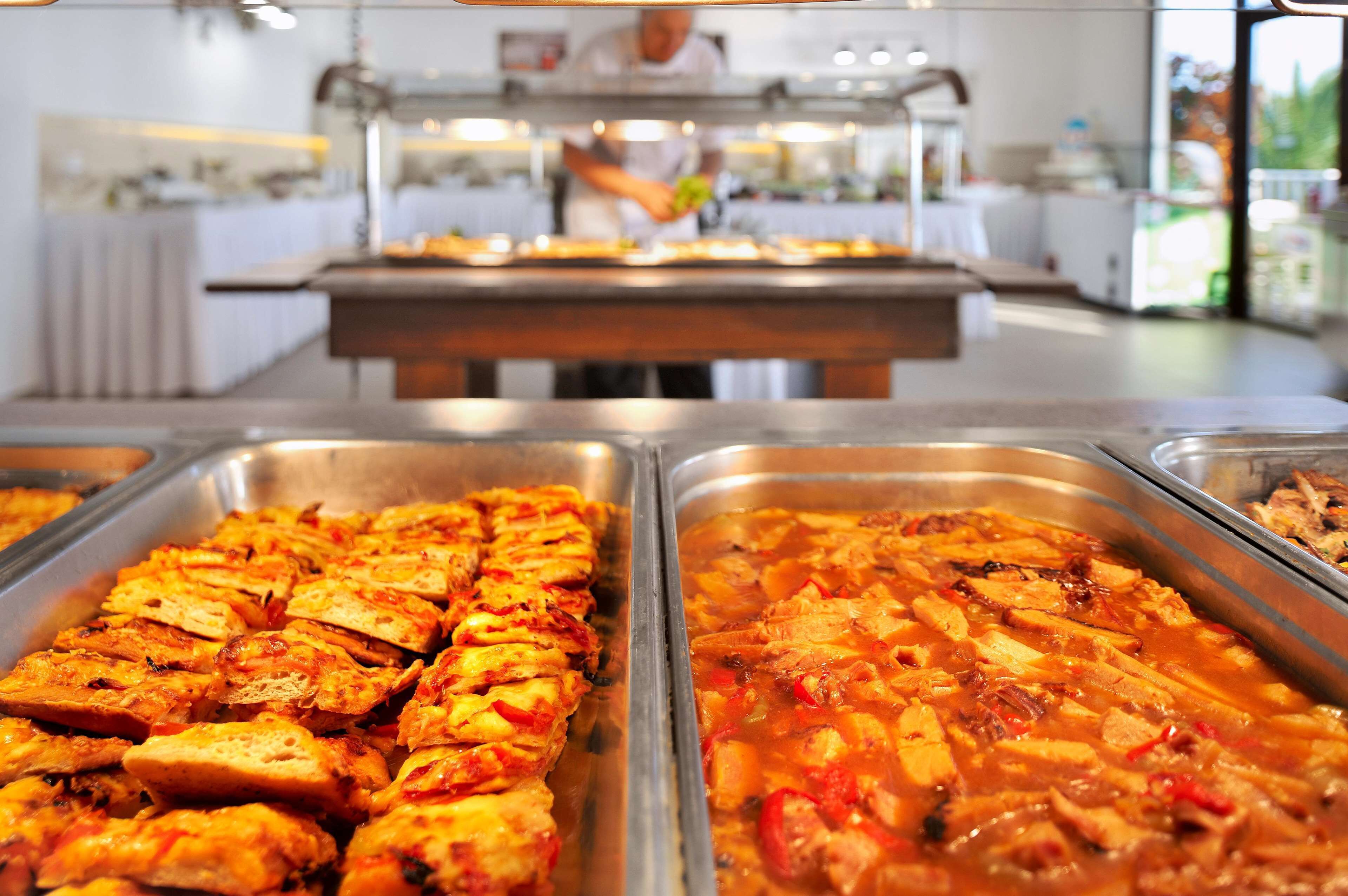 A buffet with various food items, including grilled chicken and a stew.