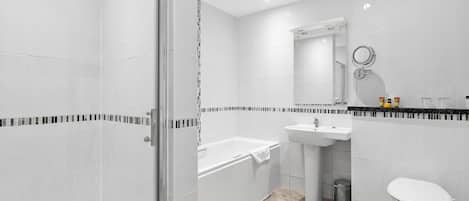 A modern bathroom with a glass-enclosed shower, a bathtub, a sink, and a toilet.