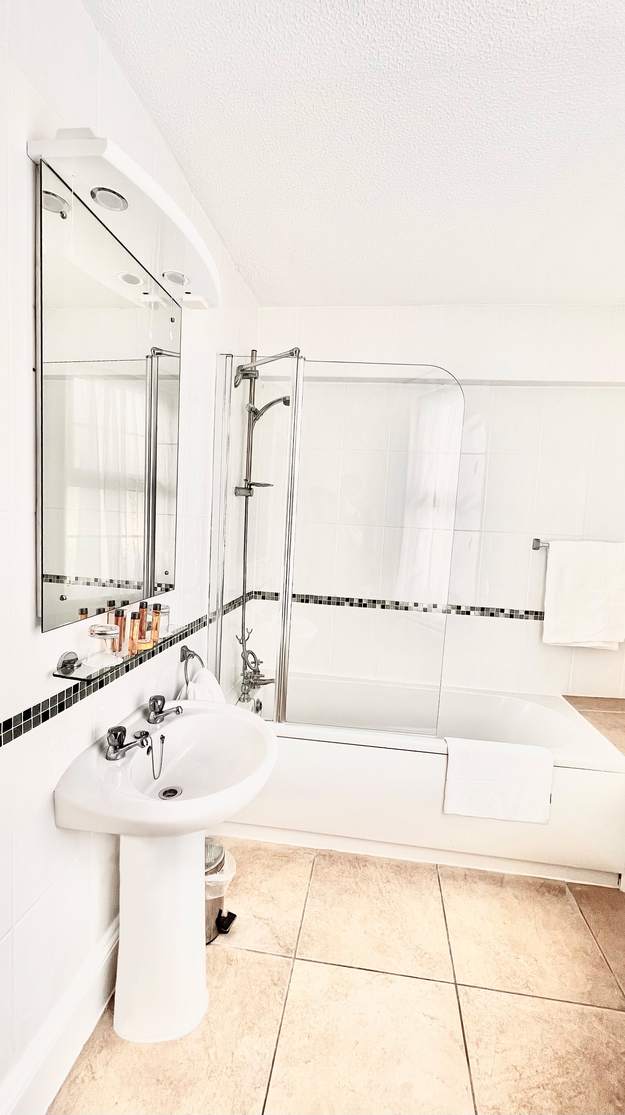 A modern bathroom with a sink, mirror, and bathtub.
