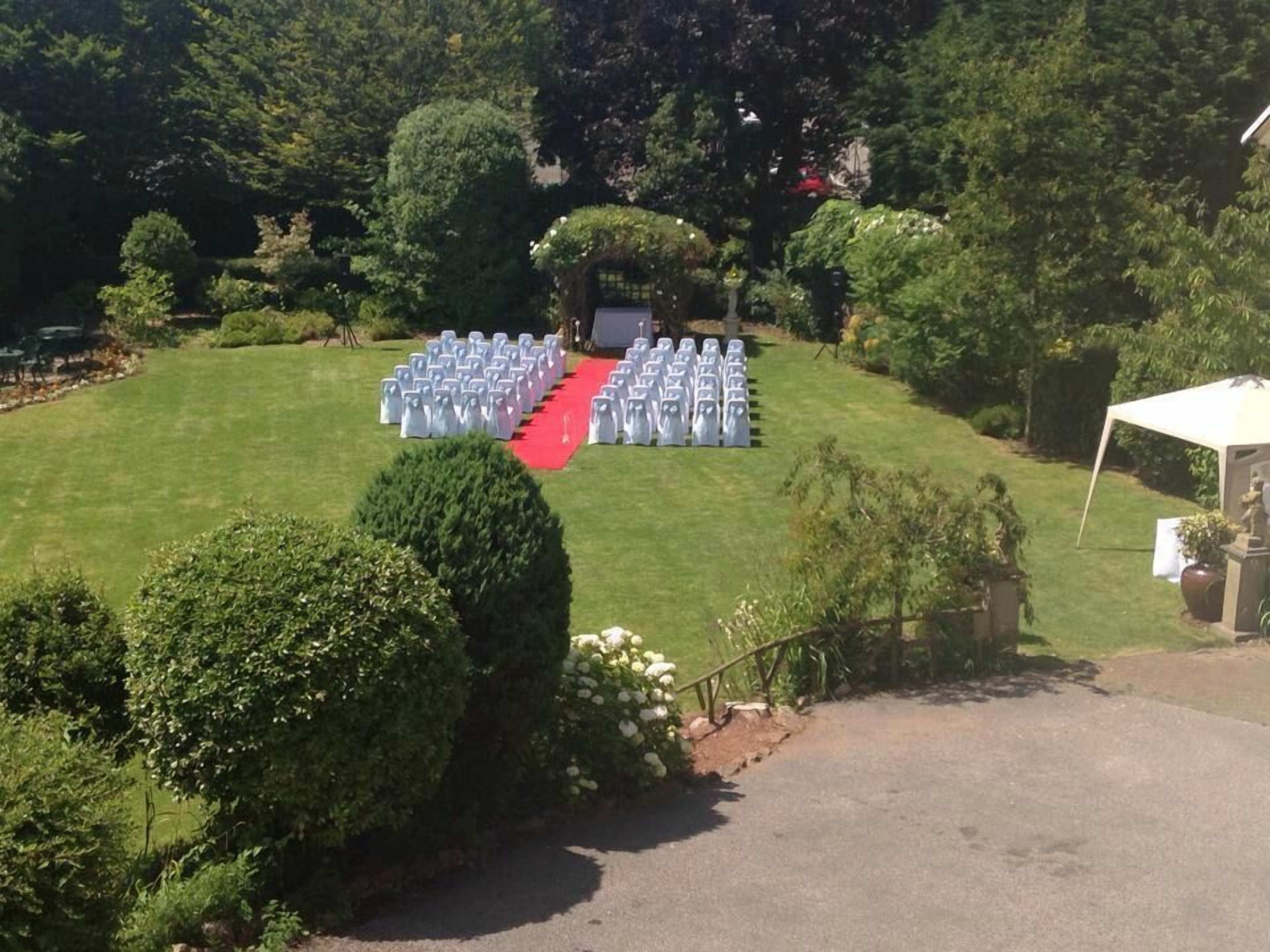 A grassy outdoor area with a red carpet leading to a white tent.