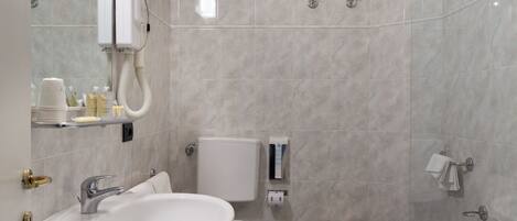 A modern bathroom with a sink, toilet, bidet, and bathtub.