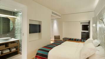 Ein modernes Hotelzimmer mit einem großen Bett, einem Nachttisch, einem Flachbildfernseher, einem Badezimmer mit Waschbecken und Spiegel sowie einem Fenster.