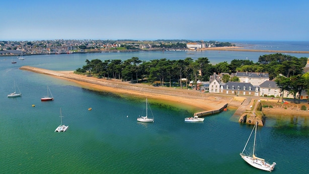 A coastal town with a marina, boats, and houses along the shore.