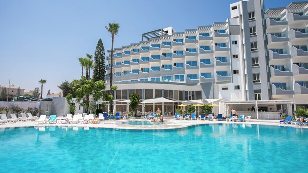 A hotel with a swimming pool, multiple balconies, and a bar area. - Papouis Protaras Hotel (Paralimni)
