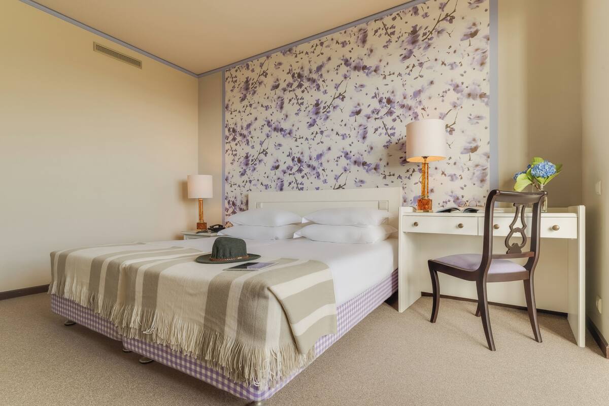 Ett hotellrum med en säng, ett skrivbord och en stol.