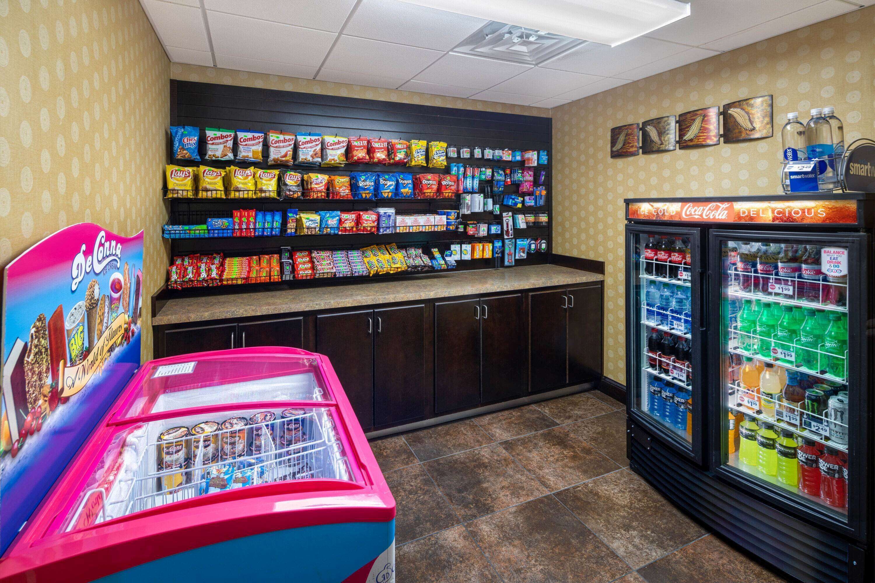 A vending area with snacks and beverages, including a Coca-Cola refrigerator and a red vending machine.