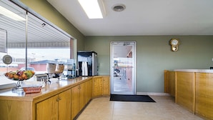 A kitchen with wooden cabinets, a window, a refrigerator, and a microwave.