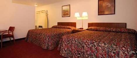A hotel room with two beds, a desk, and a chair.