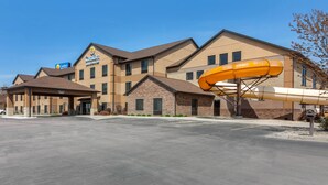 Un hotel con entrada cubierta, un tobogán grande y un letrero de Comfort Suites by Wyndham.