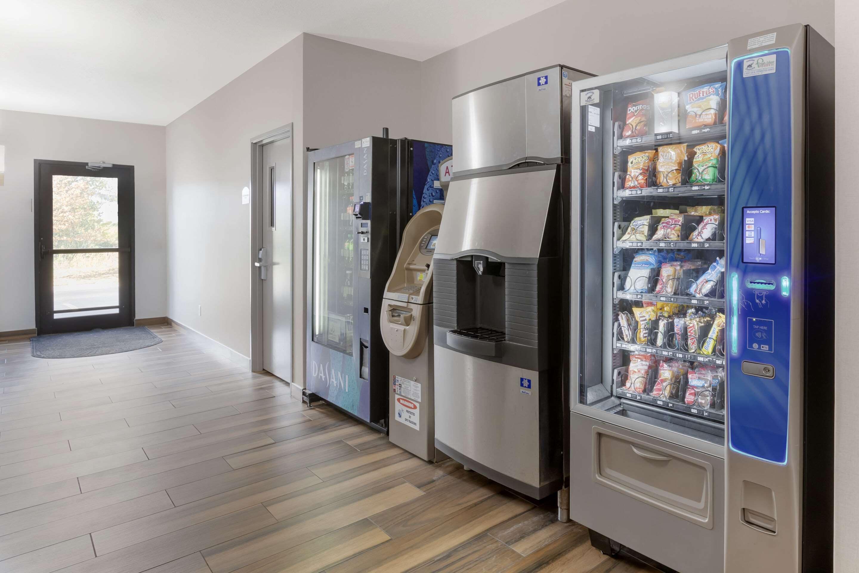 A hallway with vending machines and a door.
