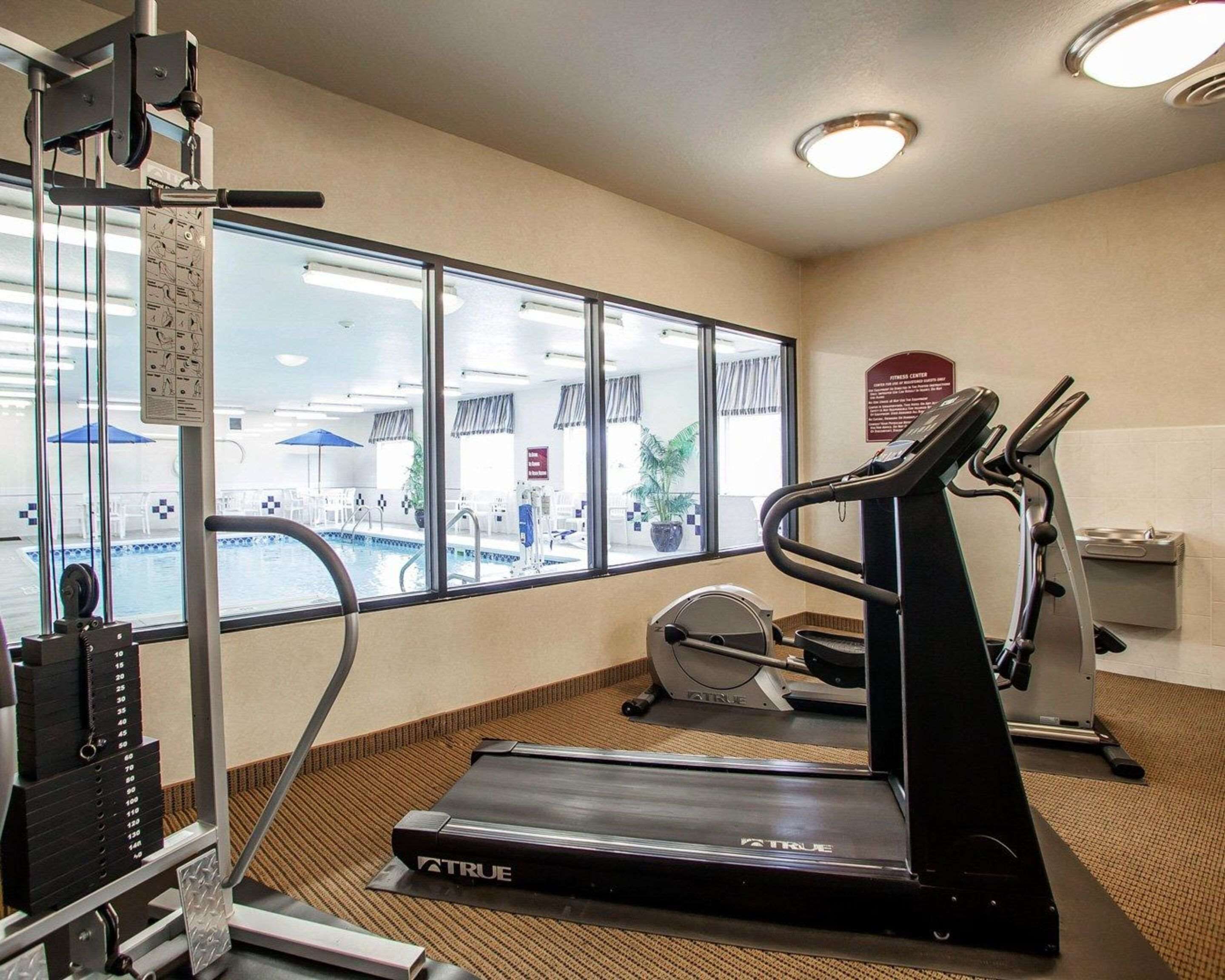 Un gimnasio con cintas de correr, una bicicleta estática y una máquina de pesas.