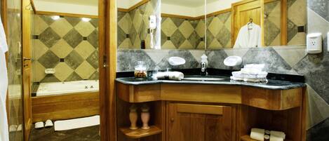 A bathroom with a wooden vanity, a bathtub, and a large mirror.