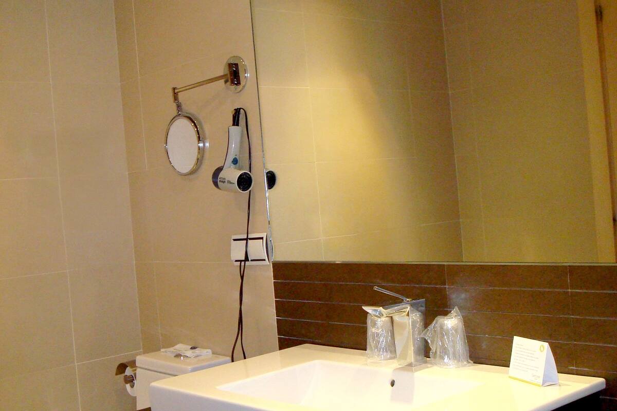 A bathroom with a white sink, a mirror, and a toilet.