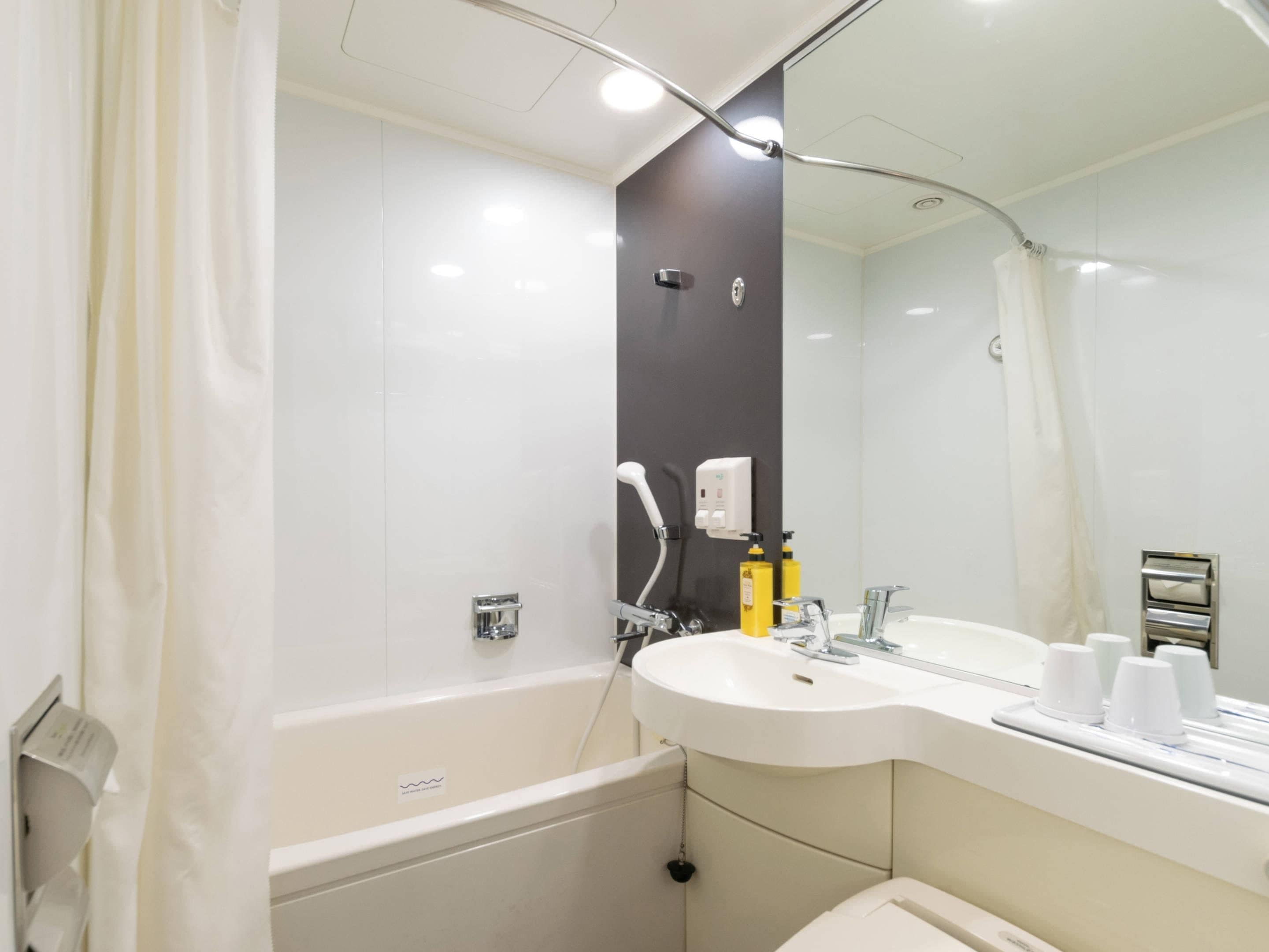 Un baño moderno con bañera, lavabo y espejo.