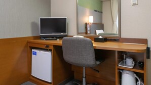 A hotel room with a desk, a television, a mini-fridge, a chair, a mirror, and a coffee maker. - Comfort Hotel Toyama (Toyama)