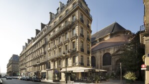 Un edificio histórico de varias plantas, con amplios ventanales y una entrada destacada en esquina.