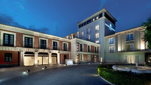 Un hotel con patio, varias construcciones y una entrada bien iluminada.