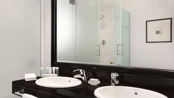 Un baño moderno con dos lavamanos, un espejo grande y un cuadro enmarcado en la pared.
