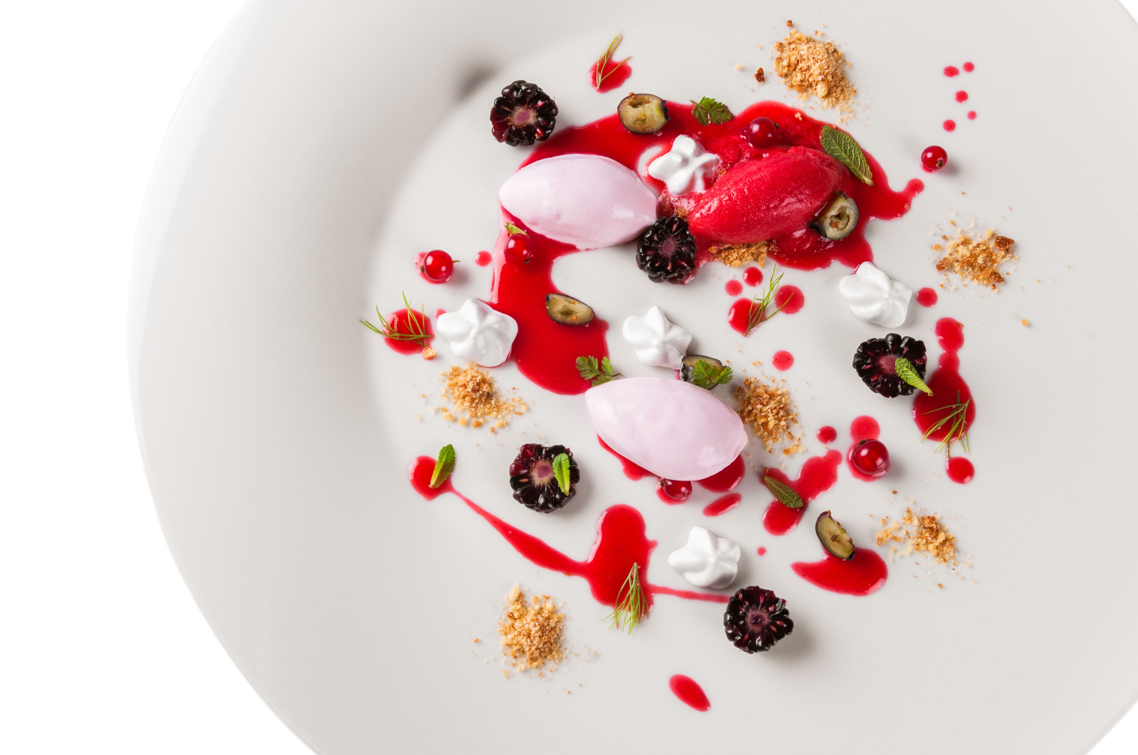 A dessert plate with various fruits, meringue, and a scoop of ice cream.