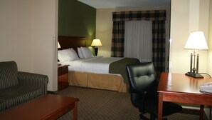 A hotel room with a bed, a desk, a chair, a sofa, and a lamp. - Holiday Inn Express & Suites - Greenwood by IHG (Greenwood)