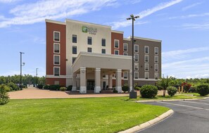 A Holiday Inn Express & Suites building with a covered entrance, multiple windows, and a parking lot. - Holiday Inn Express & Suites - Greenwood by IHG (Greenwood)