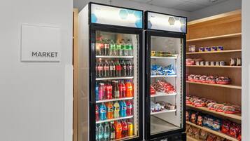 A vending machine area with a 'MARKET' sign, stocked with various beverages and snacks.