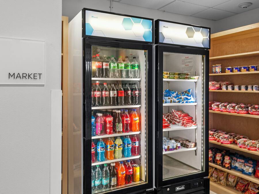 A vending machine area with a 'MARKET' sign, stocked with various beverages and snacks.