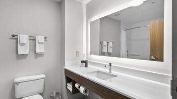 A modern bathroom with a toilet, sink, and mirror.