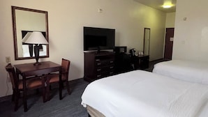 A hotel room with a bed, a desk with a lamp, a TV, and a dresser. - Country Inn & Suites by Radisson, Terrell (Terrell)
