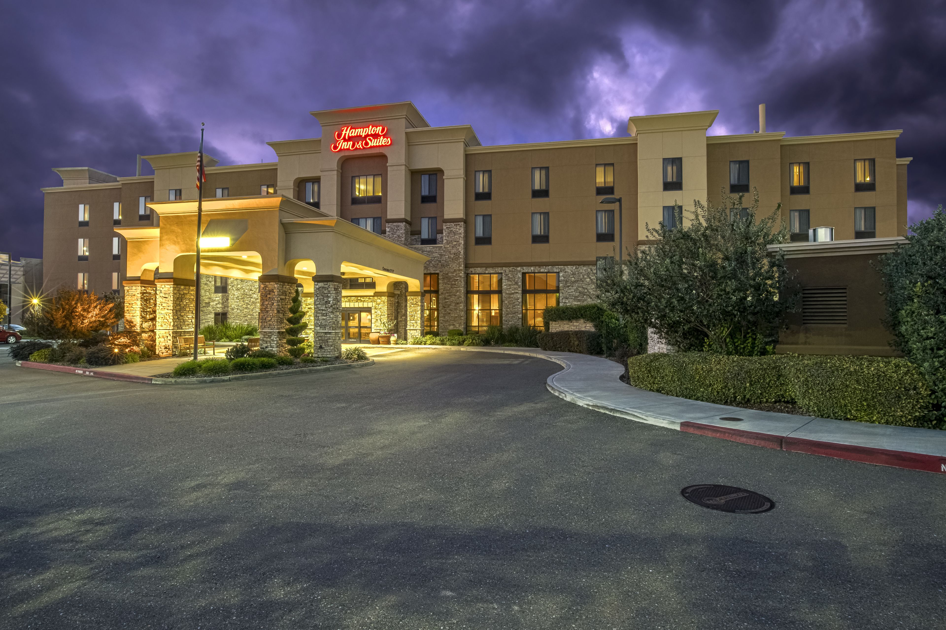 Un hotel con una entrada destacada, varios pisos y una fachada bien iluminada.