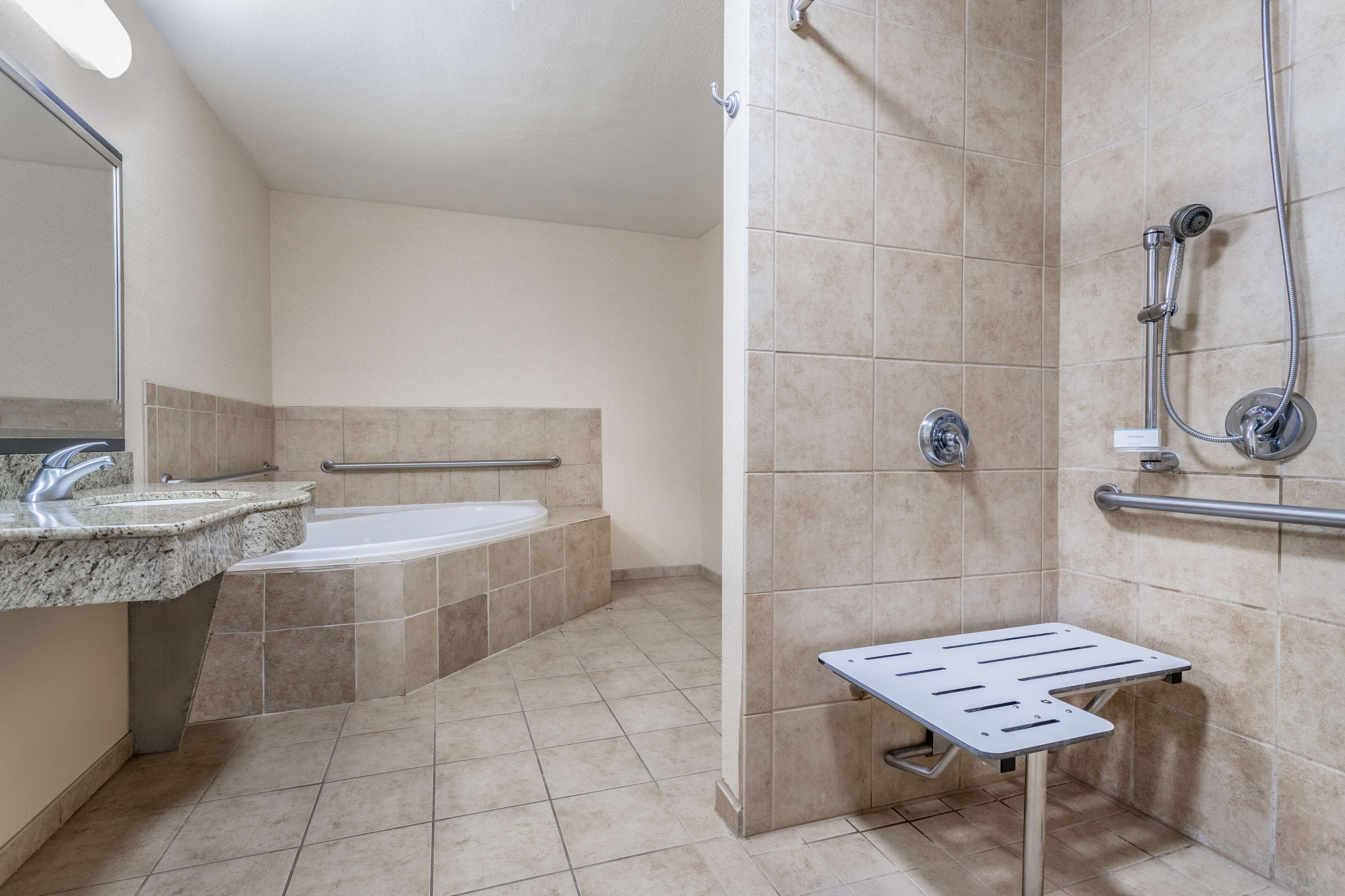 Een badkamer met een wastafel, bad en douche.