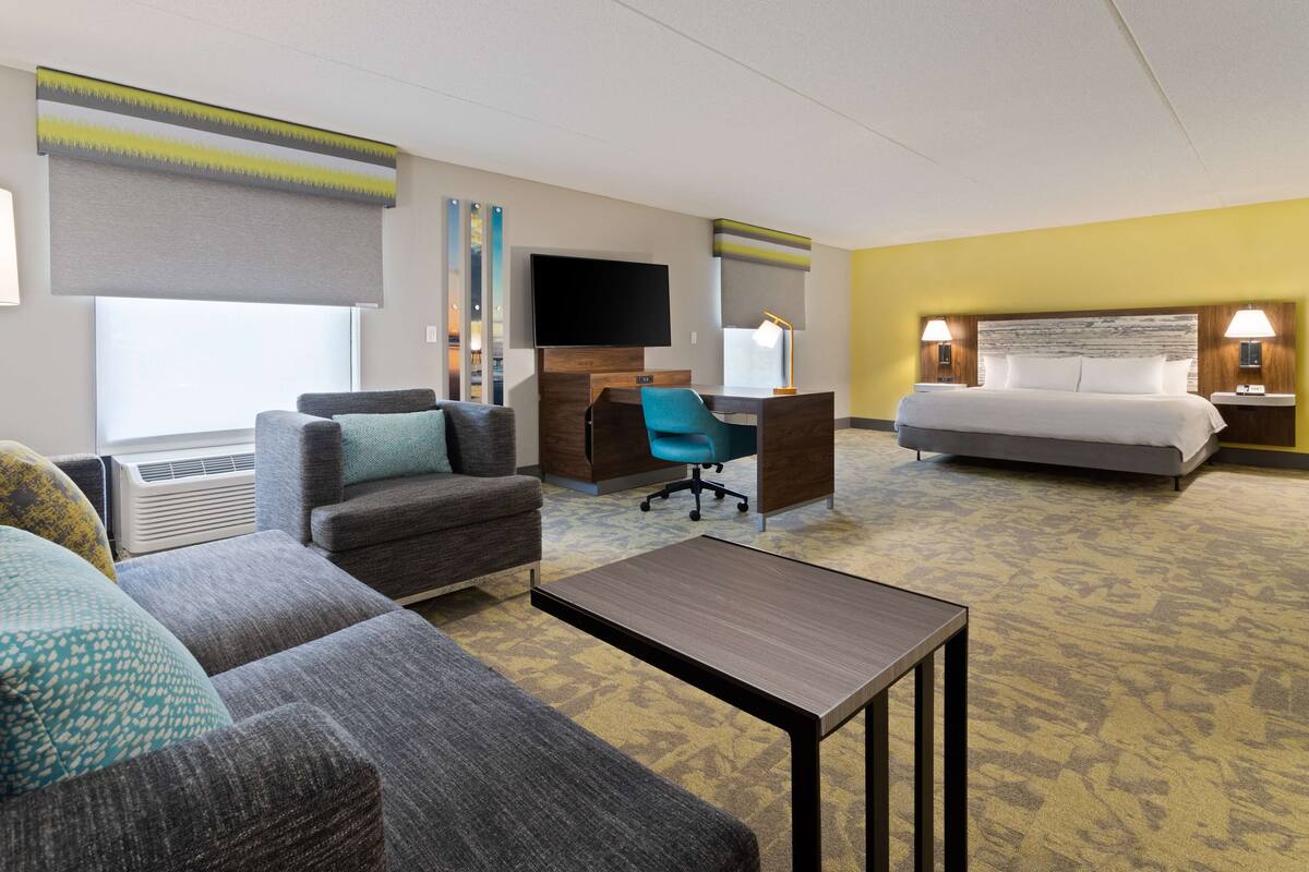 Une chambre d’hôtel équipée d’un canapé, d’un bureau, d’un lit et d’une télévision.