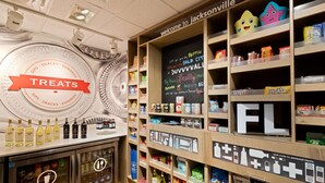 A treats display with a variety of snacks and drinks, including popcorn and sodas. - Hampton Inn Jacksonville-I-295 East/Baymeadows (Jacksonville)