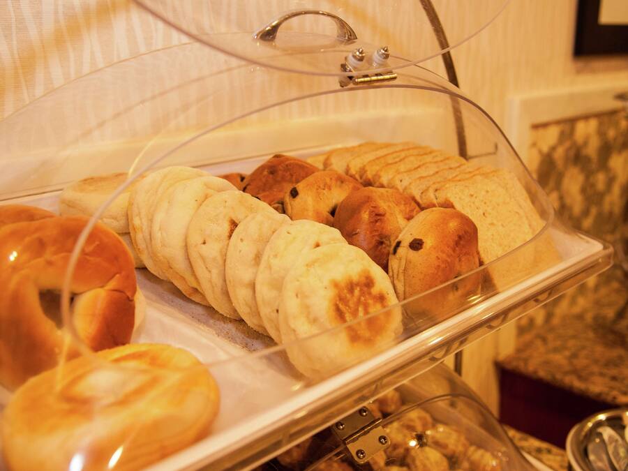 Un buffet de petit-déjeuner proposant diverses pâtisseries, présenté sous une cloche de verre.