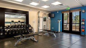 A gym with weightlifting equipment, dumbbells, and a bench. - Hampton Inn Santa Barbara/Goleta (Goleta)