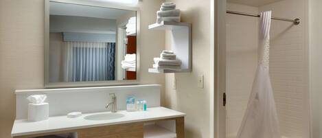 A modern bathroom with a white sink, mirror, and towel rack.