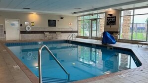 Une piscine intérieure à l’eau claire, dotée d’un poste de surveillance pour les maîtres-nageurs et offrant une vue sur l’extérieur grâce à de grandes fenêtres.