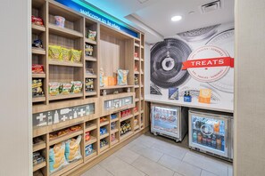 A snack section with shelves stocked with various packaged snacks and a refrigerated display case.