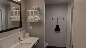A bathroom with a sink, mirror, towel rack, and toilet.