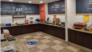 Un espace cuisine doté d’un sol à carreaux, de plans de travail et de divers appareils électroménagers.