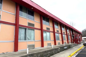 Un edificio de techos rojos y paredes anaranjadas, con amplias ventanas y una escalera de incendios.
