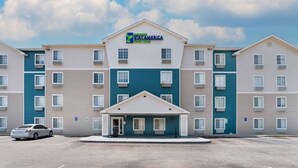A StayAmerica hotel with a central entrance, multiple floors, and a parking lot. - Extended Stay America Select Suites - Montgomery (Montgomery)