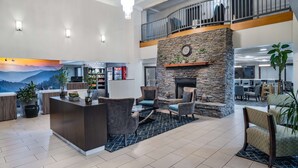 A spacious lobby with a reception desk, seating area, and a stone fireplace.