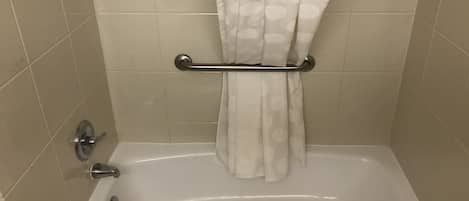A bathroom with a bathtub, a towel rack, and a toilet.