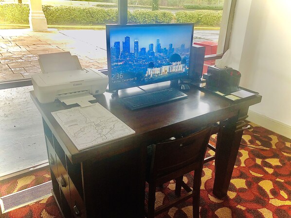 Un escritorio con una computadora, documentos e impresora.