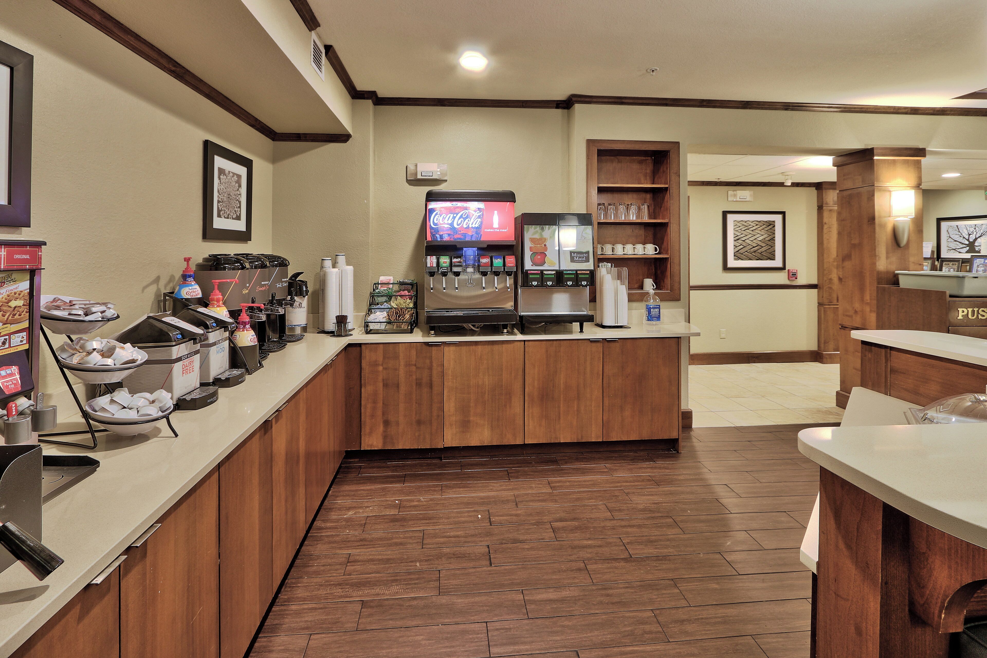 Un hall d’hôtel équipé d’un coin café, d’un réfrigérateur à boissons Coca-Cola et d’un distributeur de boissons Minute Maid.