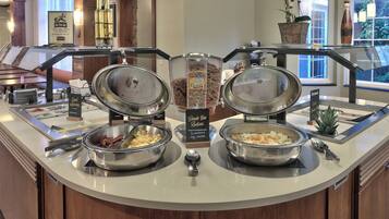 Montaje de buffet con diversas opciones de comida y una estación de café.
